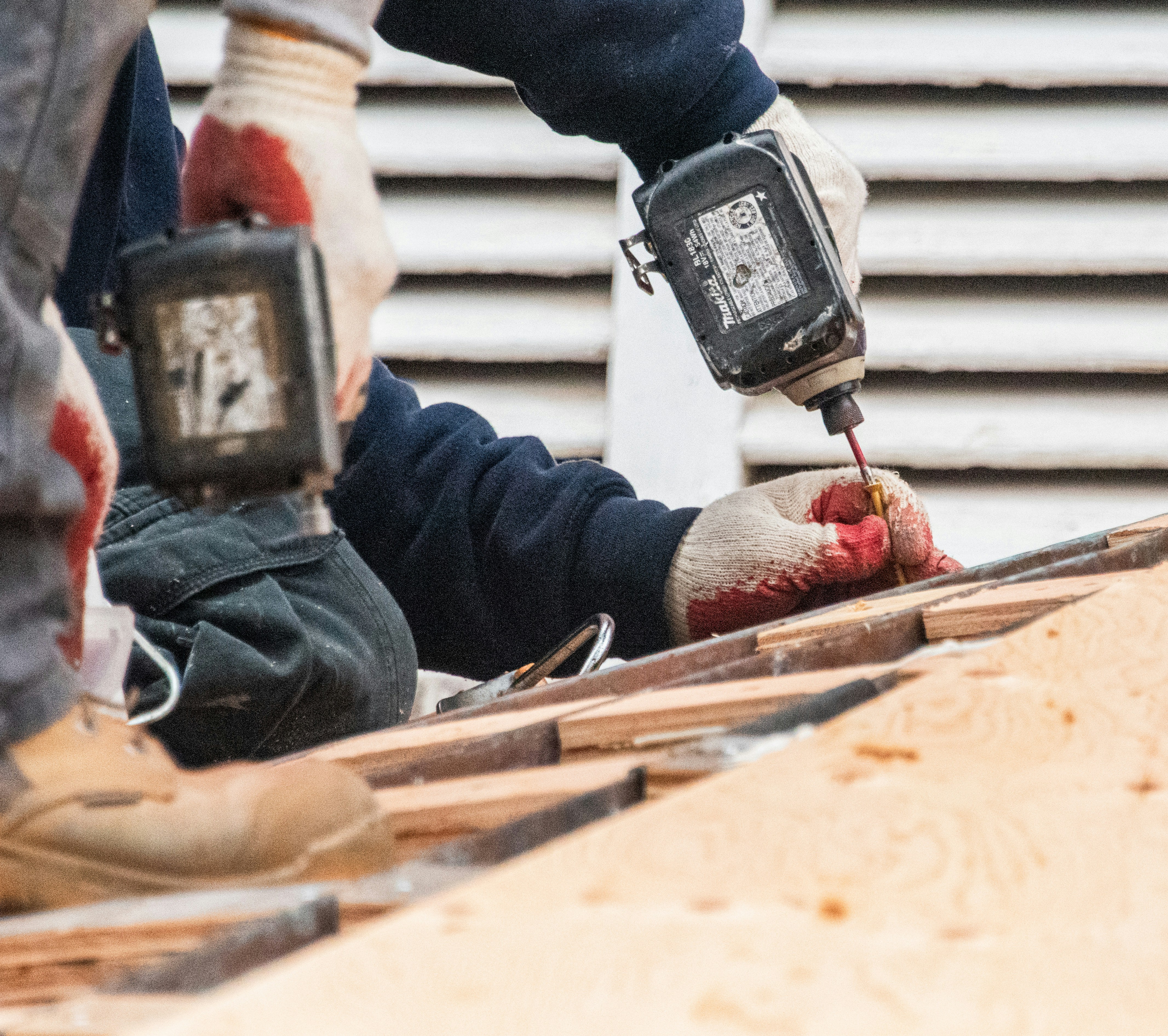 Construction workers using power tools on a building site