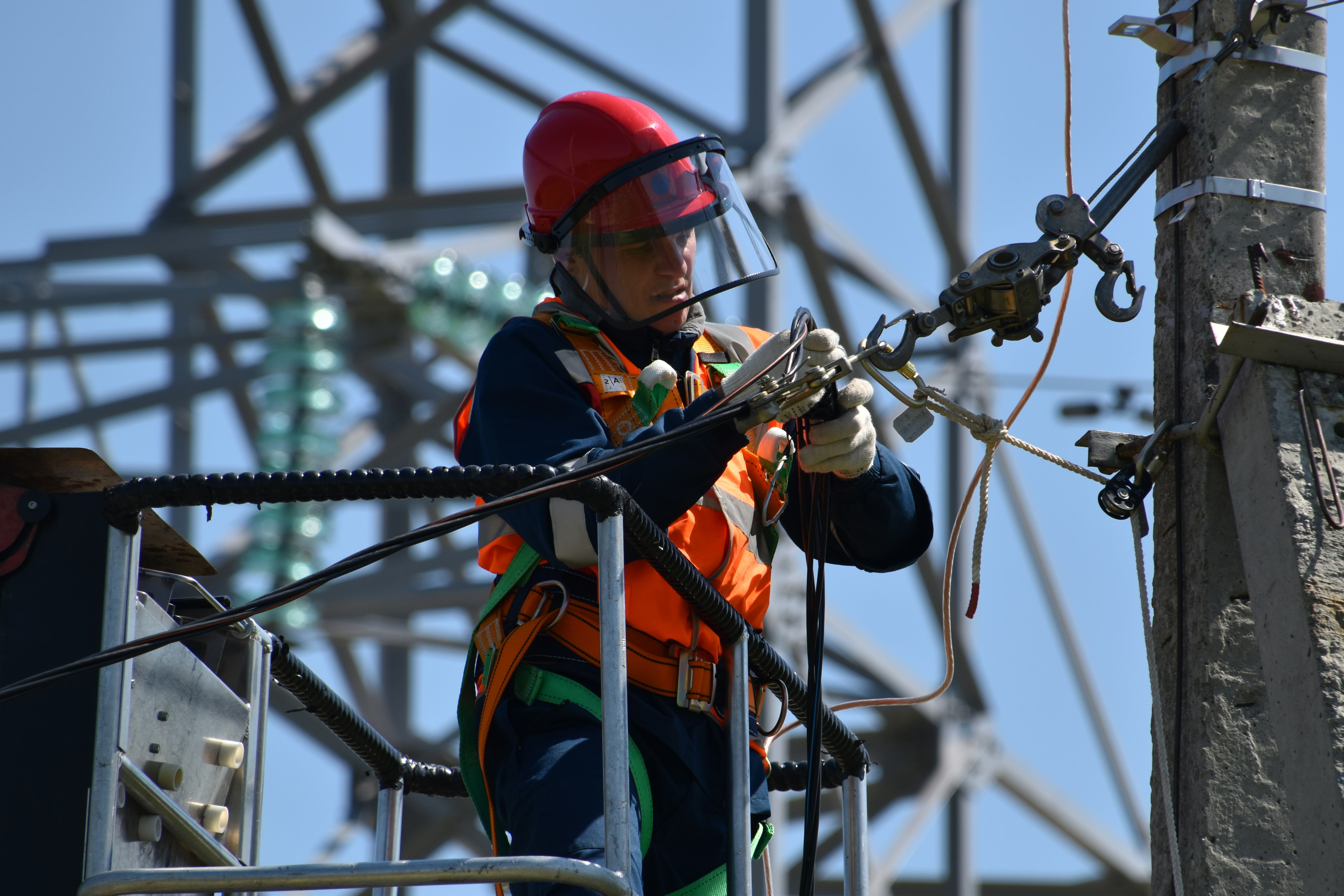 Electrical worker performing line work on elevated utility infrastructure